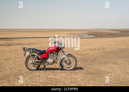 Tanzanie, Afrique de l'est - novembre, 2016: Vue latérale de la moto dans un désert chaud vide avec ciel bleu sur fond en Tanzanie Banque D'Images