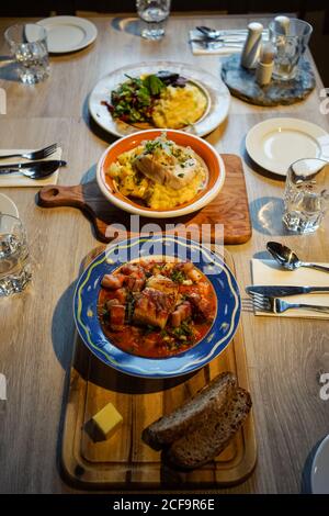 De plus de trois plats différents de poisson et légumes sur des planches de bois servis sur table avec des couverts dans le restaurant à Tromso, Norvège Banque D'Images