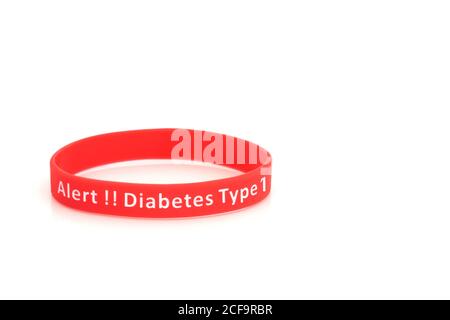 Bracelet d'alerte diabète de type 1 en silicone rouge sur fond blanc. Banque D'Images