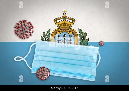 Concept de coronavirus ou de particules Covid-19 et masque chirurgical visage sur le drapeau de Saint-Marin en arrière-plan. Banque D'Images