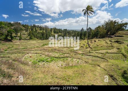 De dessus beau milieu rural y compris les champs en terrasse contre solitaire établissement sur une colline sous un ciel bleu avec des nuages blancs luxuriants En été en Asie du Sud-est Banque D'Images