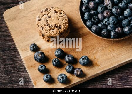 De la composition ci-dessus avec des biscuits empilés et des bleuets frais placés sur planche à découper en bois sur la barre de coupe Banque D'Images