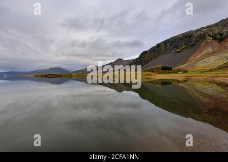 Paysage magnifique au lac Thveit en Islande. Merveille de la nature avec le ciel et la montagne reflétés dans un miroir d'eau. Magnifique backgro extérieur Banque D'Images