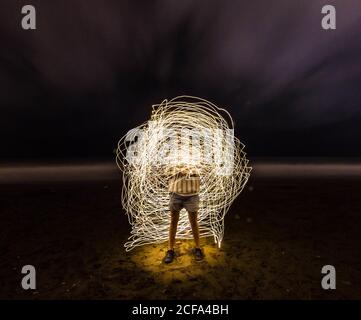 Photo en exposition prolongée d'un homme entouré de cercles de lumière Banque D'Images