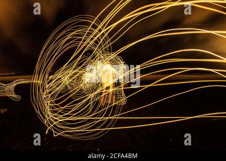 Photo en exposition prolongée d'un homme entouré de cercles de lumière Banque D'Images