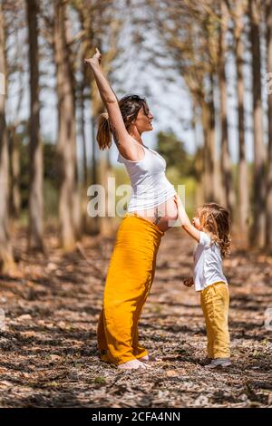 La mère enceinte et la petite fille s'amusent dans le parc Banque D'Images