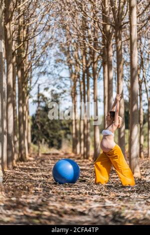 Femme enceinte adulte s'entraîner avec des pilates dans le parc pendant la journée ensoleillée Banque D'Images