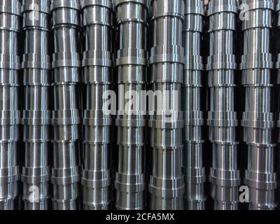 résumé de production industrielle en acier brillant empilé plein cadre avec tuyaux usinés cnc - mise au point sélective et technique de flou d'objectif Banque D'Images