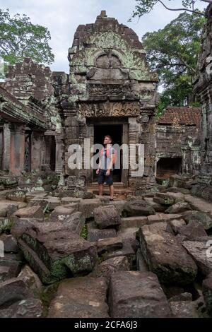 Homme insouciant avec sac à dos contemplant un endroit historique tout en étant debout Ruines du temple religieux d'Angkor Wat au Cambodge Banque D'Images