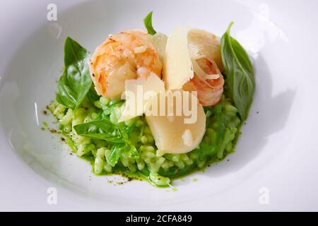 Délicieux risotto aux épinards, aux légumes verts et aux crevettes. Servi dans une vaisselle moderne. dof peu profond Banque D'Images