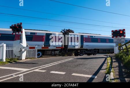 LNER Azuma train sur la ligne de chemin de fer principale de la côte est passage à niveau avec feux clignotants, Markle, East Lothian, Écosse, Royaume-Uni Banque D'Images