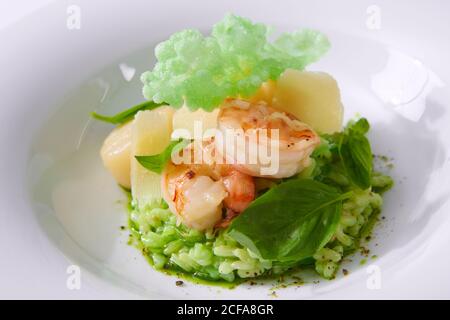 Délicieux risotto aux épinards, aux légumes verts et aux crevettes. Servi dans une vaisselle moderne. dof peu profond Banque D'Images