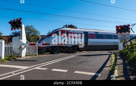 LNER Azuma train sur la ligne de chemin de fer principale de la côte est passage à niveau avec feux clignotants, Markle, East Lothian, Écosse, Royaume-Uni Banque D'Images