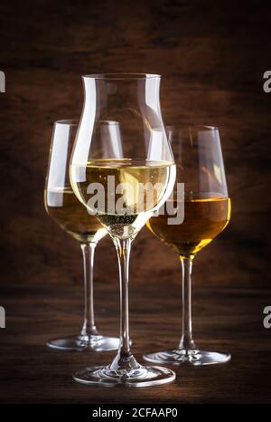 Ensemble vin blanc. Dégustation de vins, les variétés de vins blancs les plus populaires dans des verres à vin sur une table en bois vintage dans un style rustique, concentration sélective Banque D'Images