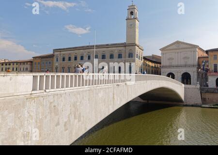 Personnes sur le pont Ponte di Mezzo à travers la rivière Arno contre Palazzo Pretorio avec sa tour et Logge di Banchi à Pise, Italie Banque D'Images