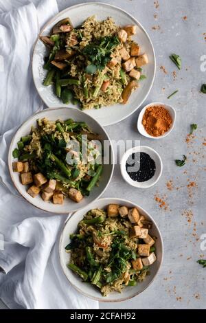 De dessus savoureux plat cuit avec du riz et des haricots verts servir sur des assiettes avec assaisonnements sur la table Banque D'Images