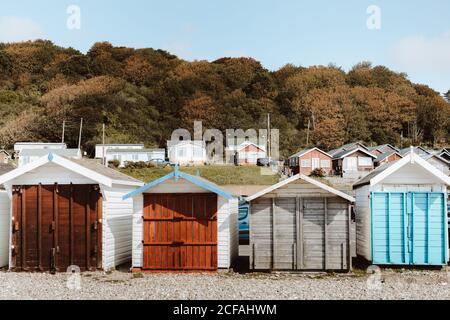 Cabines de plage de différentes couleurs avec portes fermées en bois sous le ciel bleu le jour Banque D'Images