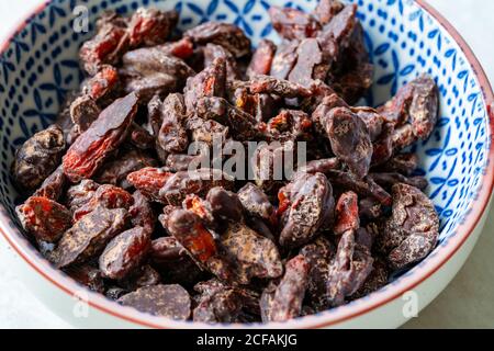 Baies de Goji / baies enrobées de chocolat amer. En-cas biologiques et crus sains de Wolfberry. Prêt à manger. Banque D'Images