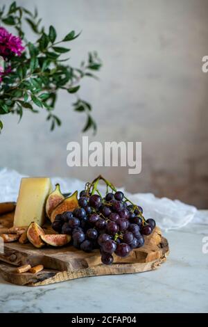 des singes à côté d'un morceau de fromage sur les planches à découper à proximité fleurs roses Banque D'Images