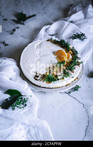 D'en haut savoureux appétissant décoré de vert mandarin et de noix gâteau à la mandarine et citruses entières bol avec cuillère tableau Banque D'Images