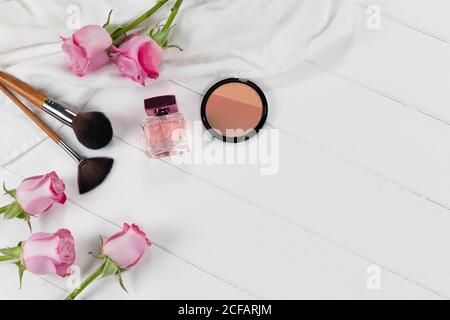 Maquillage avec fleurs roses et parfum sur blanc arrière-plan Banque D'Images