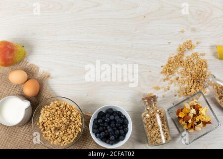 Vue sur une variété de noix et de muesli, des bols de fruits secs et des œufs sur une surface en bois Banque D'Images