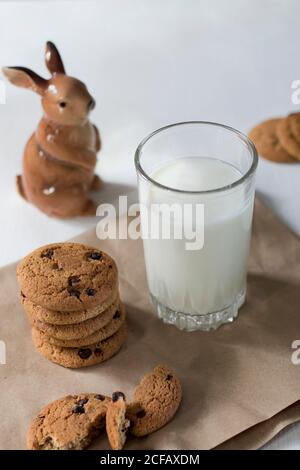 Délicieux biscuits flocons d'avoine avec raisins secs et chocolat et verre de lait sur fond de bois rustique Banque D'Images