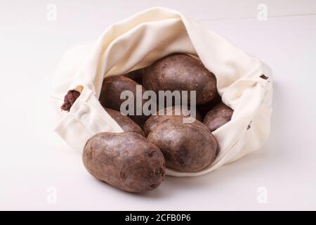 Pommes de terre violettes sur fond blanc. Banque D'Images