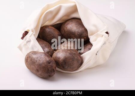 Pommes de terre violettes sur fond blanc. Banque D'Images