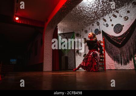 Danseuse en costume de flamenco assise en posture de danse Banque D'Images