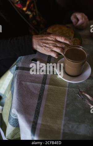 D'en haut, une femme anonyme d'âge prenant le petit déjeuner tout en étant assise à table Banque D'Images