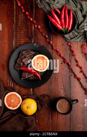 Tasse de chocolat chaud savoureux placée sur le plan d'examen en bois près assortiment de desserts et de fruits pour le petit déjeuner Banque D'Images