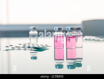 Flacons contenant des échantillons scientifiques disposés sur une table en verre Banque D'Images