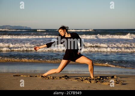 Jeune danseur sur la côte de sable avec la mer et le bleu ciel Banque D'Images Jeune danseur sur la côte de sable avec la mer et le bleu ciel Banque D'Images