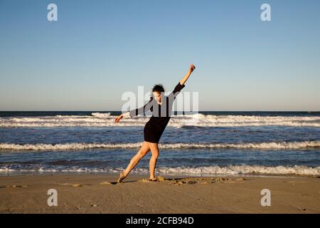 Jeune danseur sur la côte de sable avec la mer et le bleu ciel Banque D'Images Jeune danseur sur la côte de sable avec la mer et le bleu ciel Banque D'Images