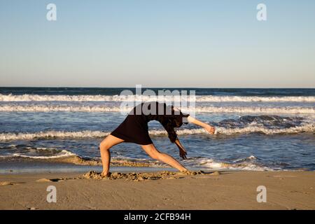 Jeune danseur sur la côte de sable avec la mer et le bleu ciel Banque D'Images Jeune danseur sur la côte de sable avec la mer et le bleu ciel Banque D'Images