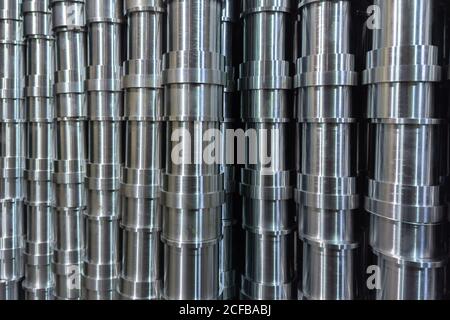 résumé de production industrielle en acier brillant empilé plein cadre avec tuyaux usinés cnc - mise au point sélective et technique de flou d'objectif Banque D'Images