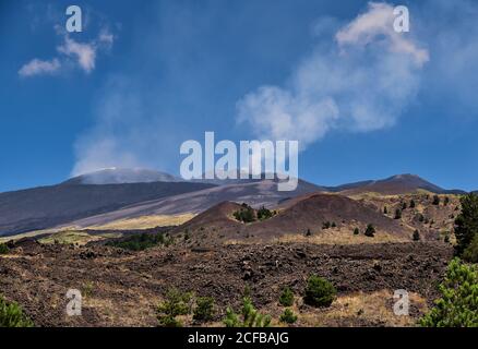 Volcan actif Mont Etna éruptant le panache de cendres, Sicile, Italie. Clairement visible la superposition des coulées de lave les plus récentes sur la plus ancienne. En avant-plan Banque D'Images