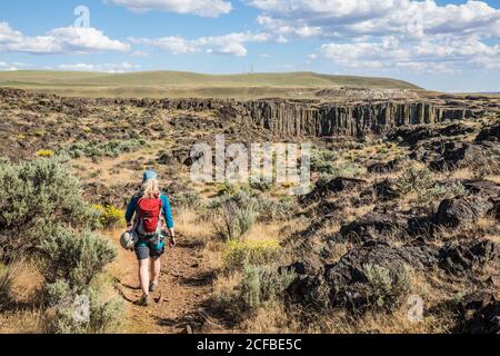 Une femme randonnée sur un sentier portant une escalade Harnais et porter un sac à dos près de Frenchmans Coulee en direction de Echo Basin dans Eastern Washingto Banque D'Images