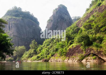 Des radeaux de bambou se déplacent le long de la rivière Nine Bend à wuyishan, dans la province du fujian en chine, lors d'une journée d'été brumeuse. Banque D'Images