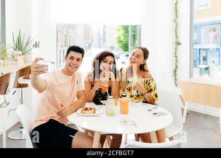 homme prenant le selfie d'amis dans le café Banque D'Images