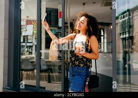 Femme ethnique gaie quittant le restaurant Banque D'Images