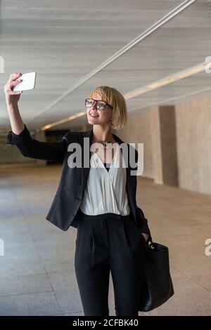 Femme d'affaires utilisant un smartphone dans le hall Banque D'Images