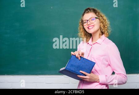 Le professeur explique le sujet dur. Pédalo tenir le livre et expliquer l'information. Concept d'éducation. Femme enseignante devant le tableau de surveillance. Professeur meilleur ami des apprenants. Passionné par la connaissance. Banque D'Images