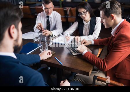 Camarades de classe femmes et hommes célébrant l'examen de mathématiques de la pathing, se sentant excitant et gai , donnant élevé cinq pendant la réunion informelle en amical Banque D'Images