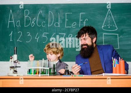 Jouez avec des liquides. Professeur et laboratoire de chimie de garçon. Exemple personnel inspirant. Connaissances scolaires. Journée de la connaissance vacances de septembre. Connaissances de base en chimie. Étudier la chimie et la biologie. Banque D'Images