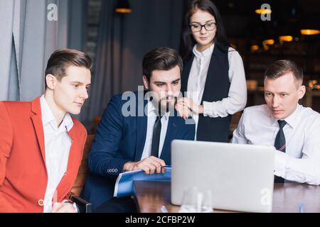 Camarades de classe femmes et hommes célébrant l'examen de mathématiques de la pathing, se sentant excitant et gai , donnant élevé cinq pendant la réunion informelle en amical Banque D'Images