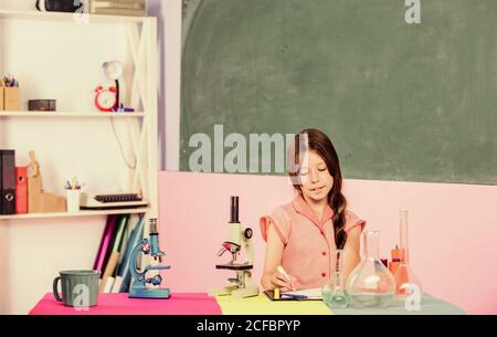 Formation en biologie. Leçon de science. Laboratoire scolaire. Petite fille au microscope. Tubes de test de classe biologie pour fille. Expérience scientifique. Leçon fascinante. Explorez la microbiologie. Étude de la biologie. Banque D'Images