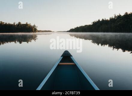 Arc d'un canot le matin sur un lac brumeux en Ontario, au Canada. Banque D'Images