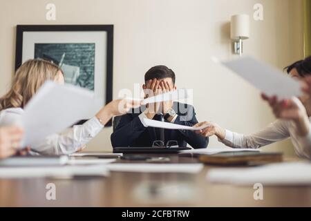 Businessman having maux de tête lors d'une rencontre d'affaires - personne dépressive avec des problèmes financiers Banque D'Images